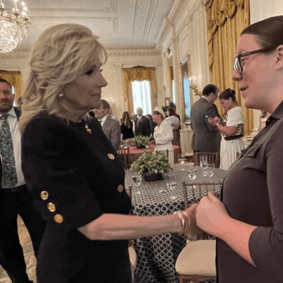 A woman is shaking hands with another woman in a room.