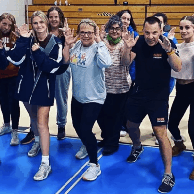A group of people posing for a photo in a gym.