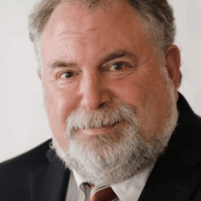 A man in a suit and tie with a beard.