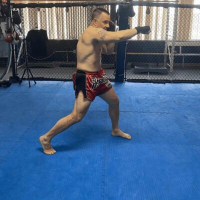 A man is doing a kick in a boxing ring.