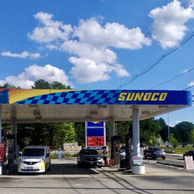 A gas station with cars parked in front of it.