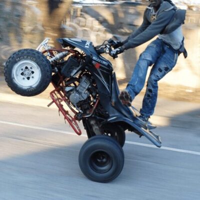 A man riding an atv on a street.
