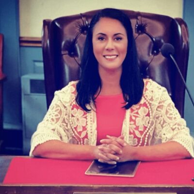 A woman sitting at a desk in front of a microphone.
