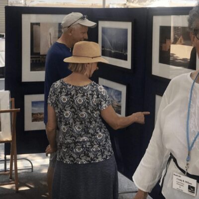 A woman standing in front of a display of photos.