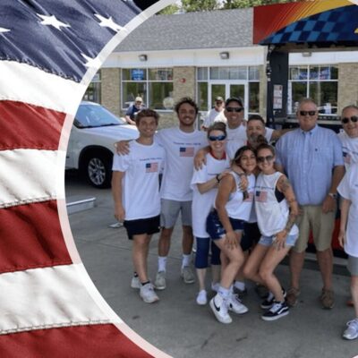 A group of people posing in front of an american flag.