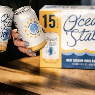 Two people are holding cans of ocean state ipa.