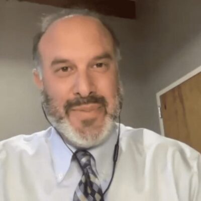 A man with a beard wearing a shirt and tie.