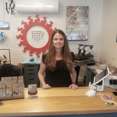 A woman standing behind a counter in a shop.