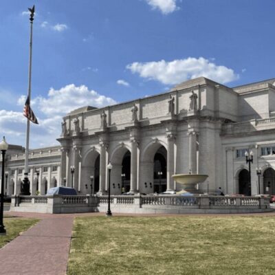 A large white building with flags in front of it.