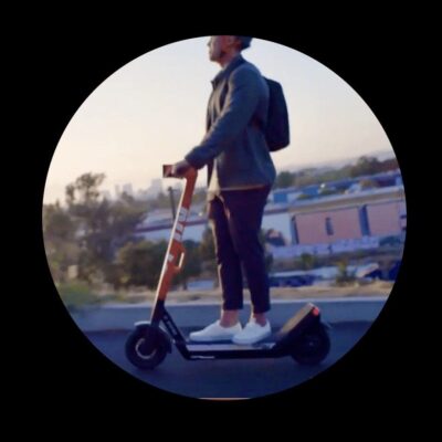 A man riding an electric scooter on a city street.