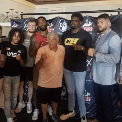 A group of men posing for a picture in front of a banner.
