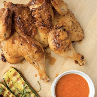 Grilled chicken and zucchini on a cutting board.