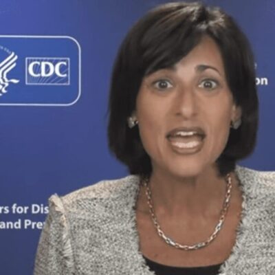 A woman in front of a blue background in front of a cdc logo.