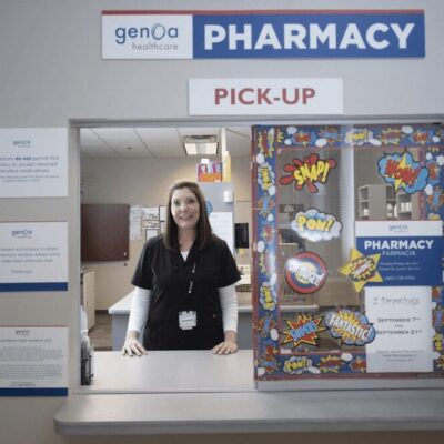A woman standing in front of a pharmacy counter.