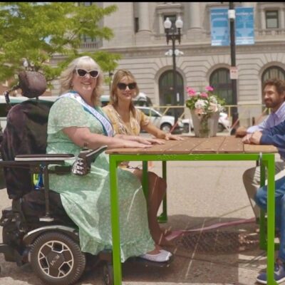 A group of people sitting around a table in a wheelchair.