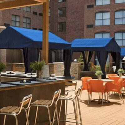 An outdoor patio with orange chairs and umbrellas.