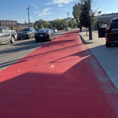 A red painted bike lane on a city street.