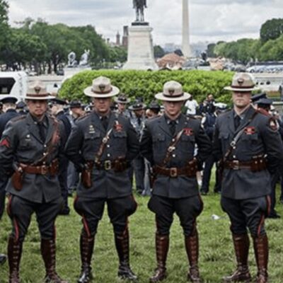 A group of uniformed police officers standing in front of a monument.