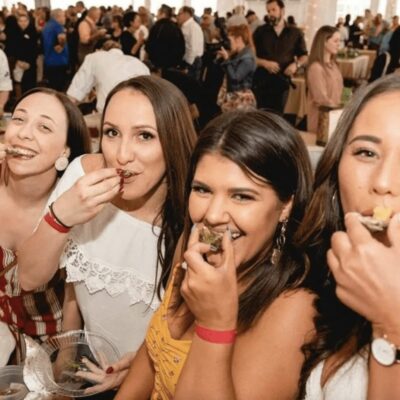 A group of people eating food in a tent.