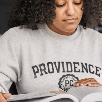 A woman reading a book at a desk.