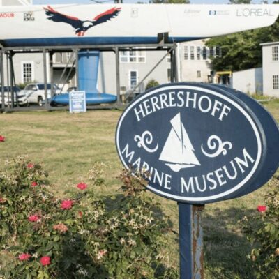 A sign with a sailboat in front of it.