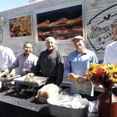 A group of people standing in front of a food truck.