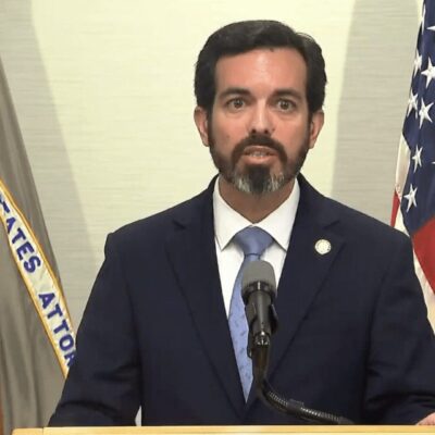A man in a suit and tie standing at a podium.