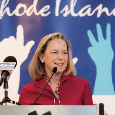 A woman giving a speech at a podium.