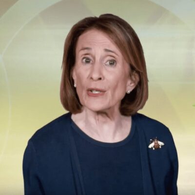 A woman is standing in front of a green screen.