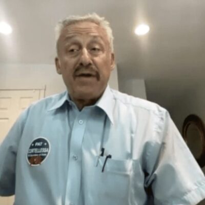 A man in a blue shirt standing in a room.