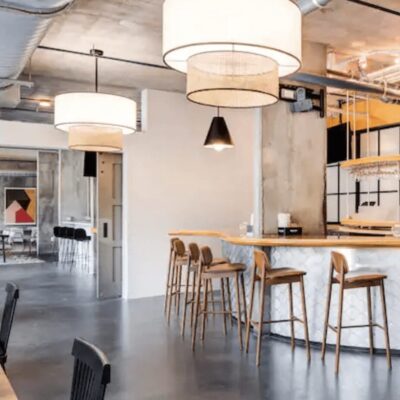The interior of a restaurant with a bar and stools.