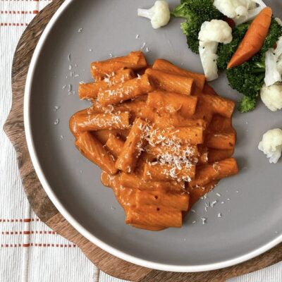 A plate of pasta with broccoli and carrots.