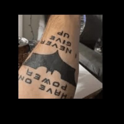A batman tattoo on a man's arm.