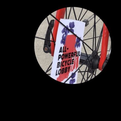 A bicycle with a sign that says all powerful bicycle lobby.