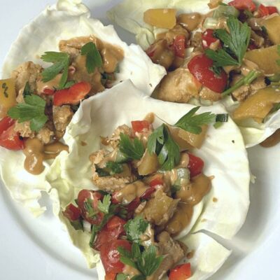 Thai chicken lettuce wraps on a white plate.