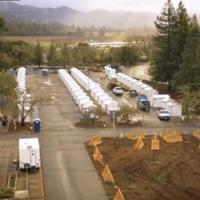 An aerial view of several tents in a parking lot.