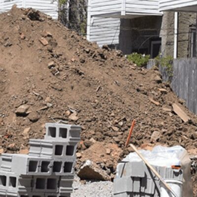 A pile of bricks in front of a house.