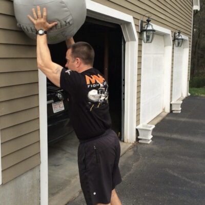A man lifting an exercise ball out of a garage.