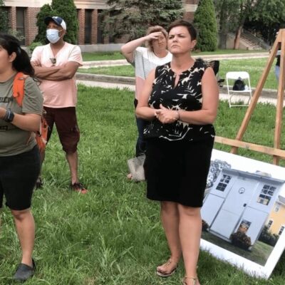 A group of people standing in front of a house.