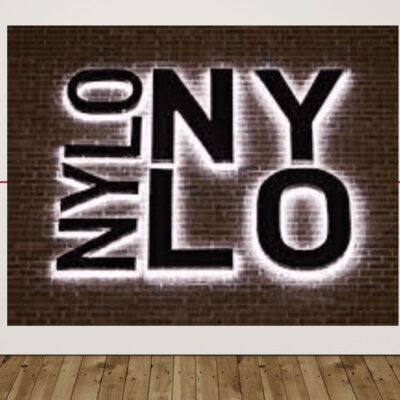 The word nylo is lit up in front of a brick wall.
