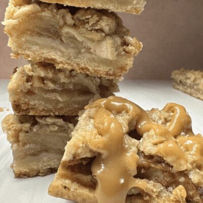 A stack of apple crumble bars on a white table.