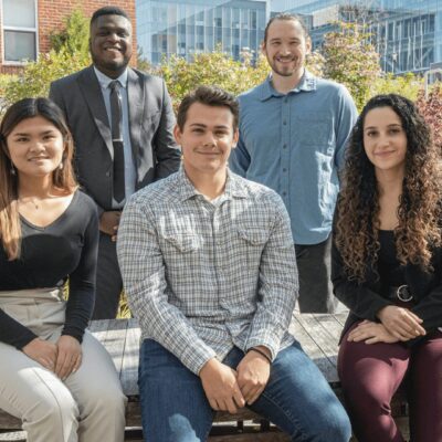 A group of people posing for a photo in front of a building.