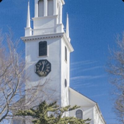 A white church with a clock tower in the background.