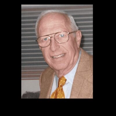 An older man wearing glasses and a tie.