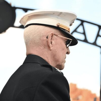 A man in a military uniform standing next to a monument.