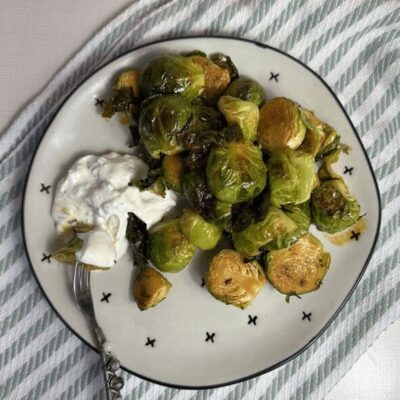 Brussels sprouts with sour cream on a plate.