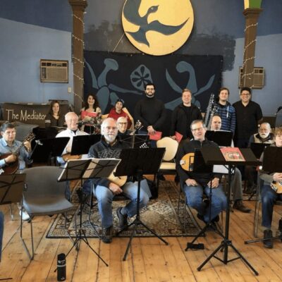 A group of people posing for a picture in a music room.