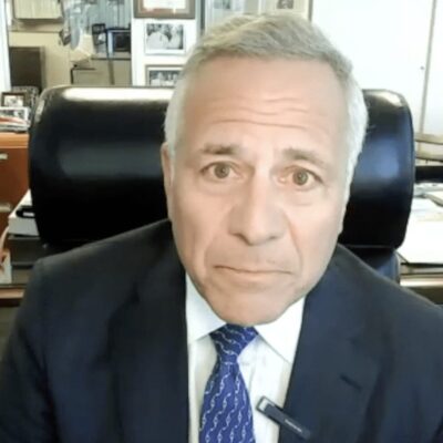 A man in a suit and tie sitting at a desk.