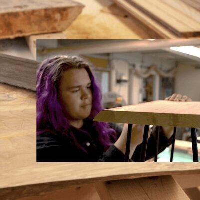 A woman is working on a piece of wood.