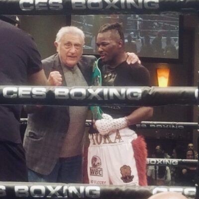 Two boxers standing next to each other in a boxing ring.